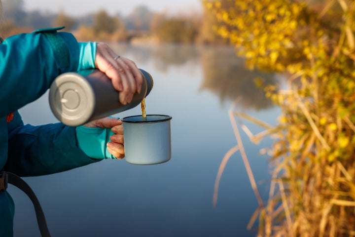 Camper pouring coffee from an insulated water bottle